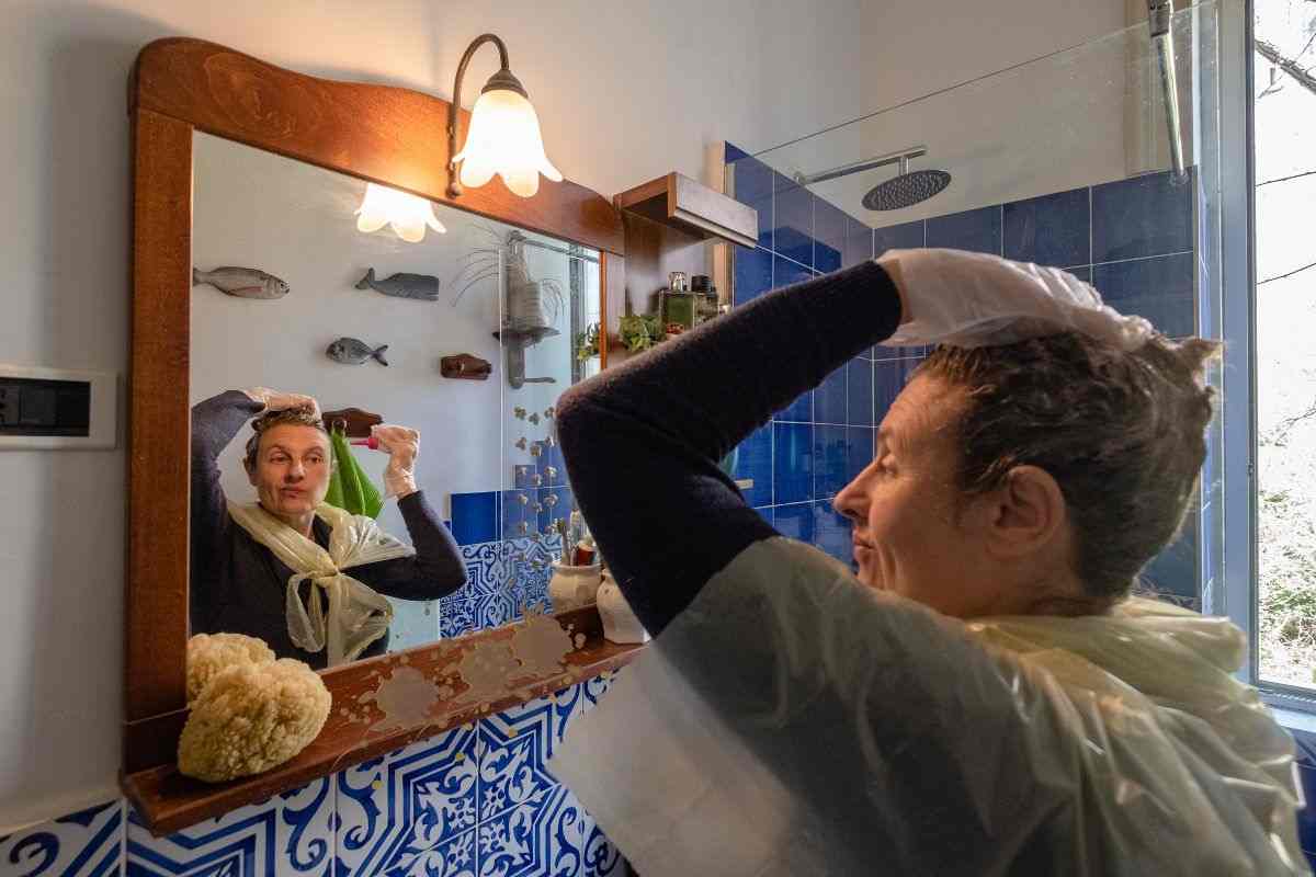 Donna in bagno mentre si fa la tinta per capelli